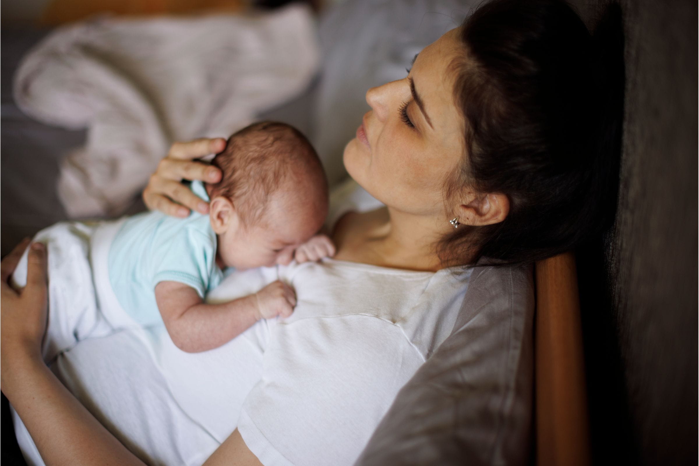 woman with postpartum depression holding her baby